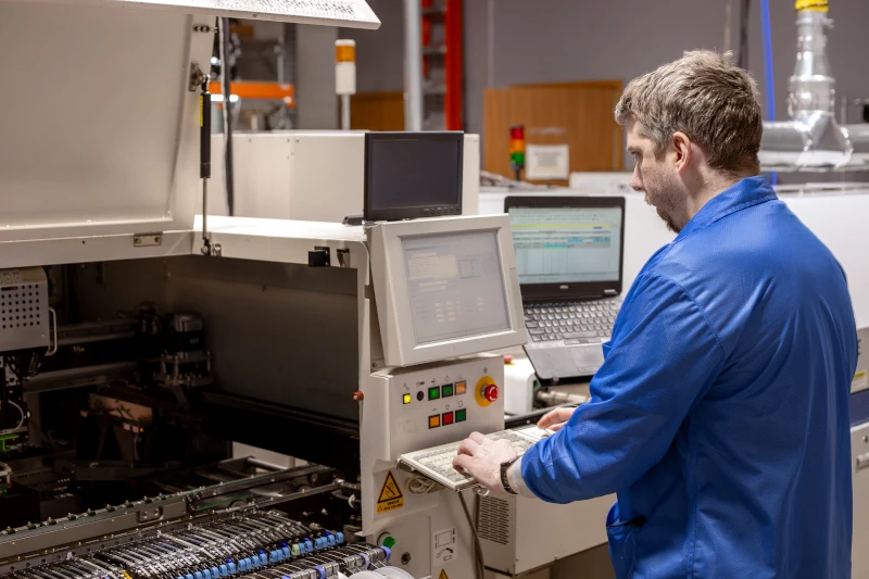 SMT technician tending a machine